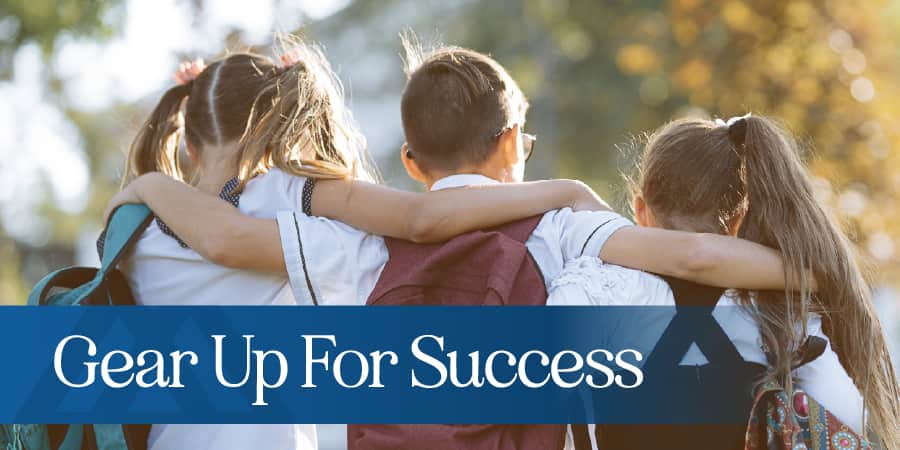 A group of three young students embracing eachother. At the bottom, the words: gear up for success.
