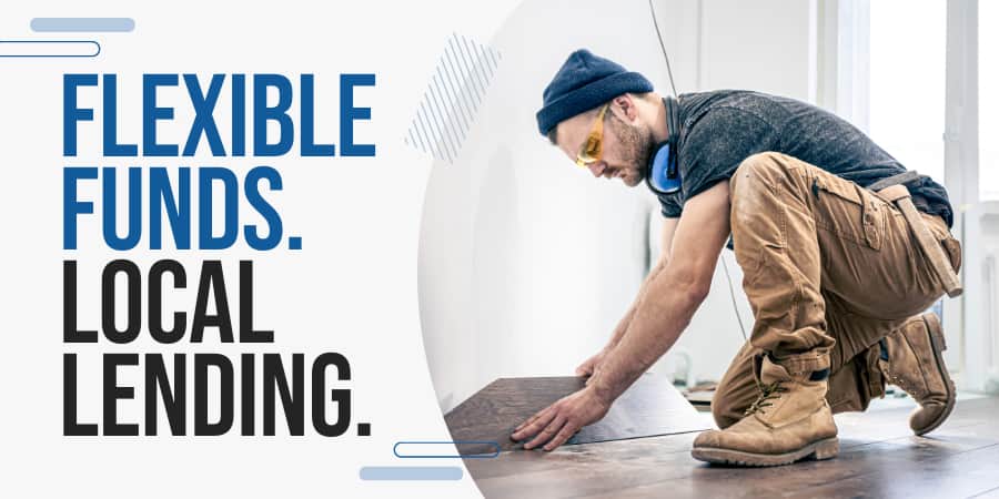 A construction worker laying hard wood floors inside a home. At the left, the words: Flexible Funds. Local Lending.