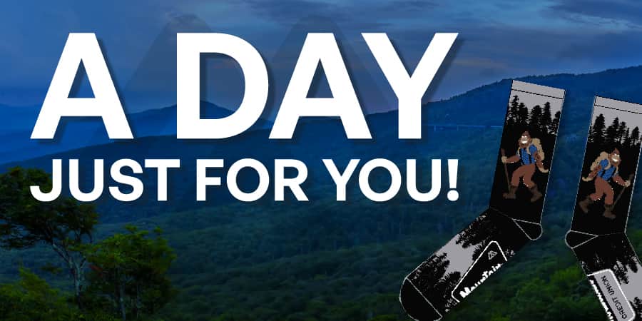 Marv socks against the blue ridge mountains. Across the top, the words: a day just for you!