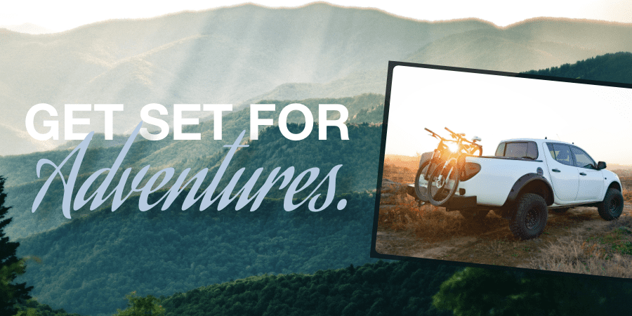 A background of mountains with an overlaid photo of a white pickup truck with mountain bikes on the back. At the left, the words: get set for adventures.