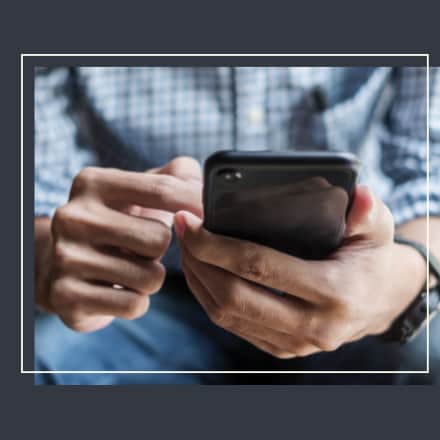 Masculine hands holding a mobile phone.
