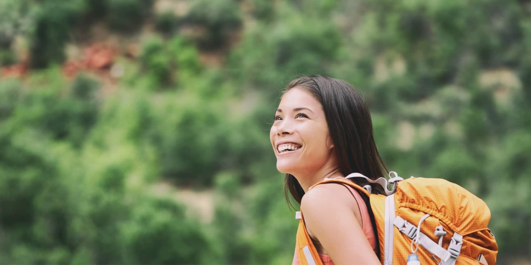 A young smiling woman hiking.