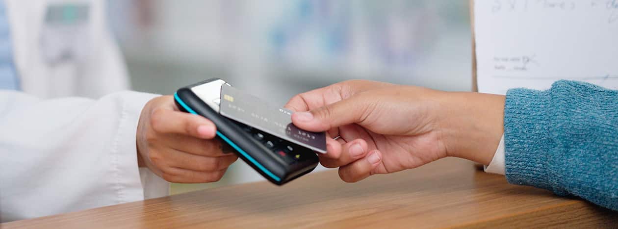 A person paying with a credit card by tapping a credit card reader.