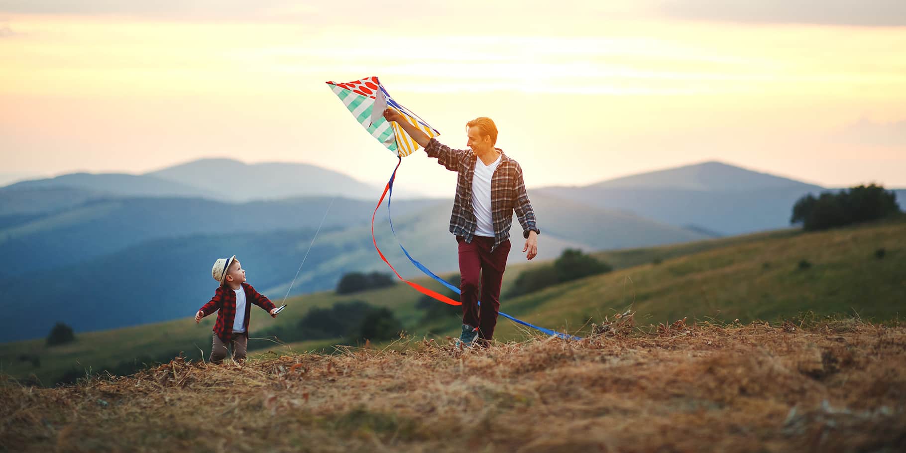 A father flying a kite with his young son.