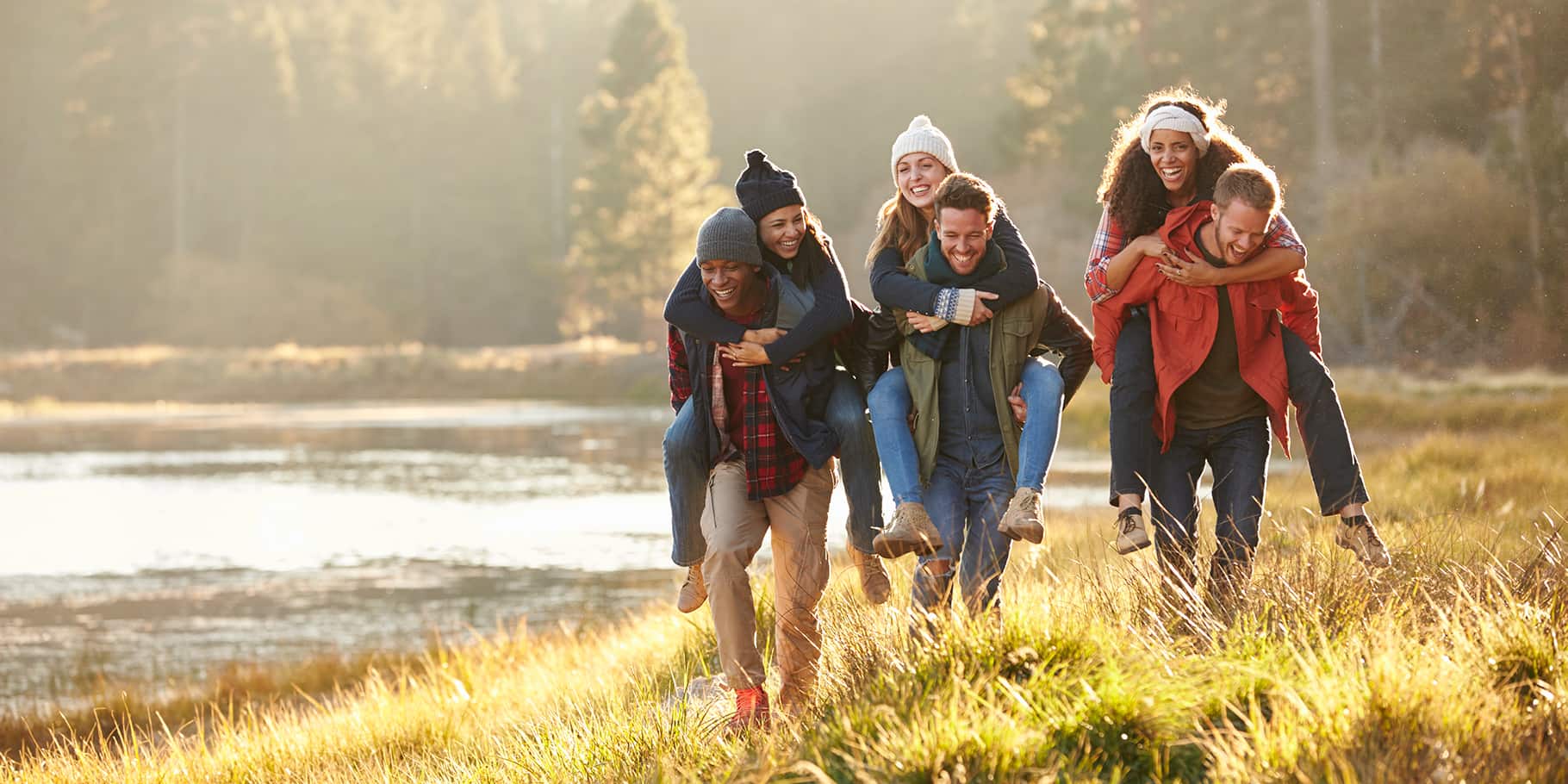 A group of three couples hiking along a river bed.